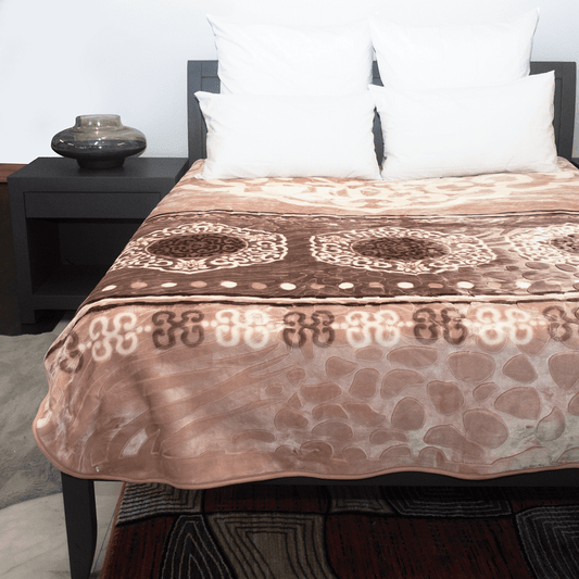 Bed with a patterned brown and beige blanket, white pillows, and a dark nightstand.