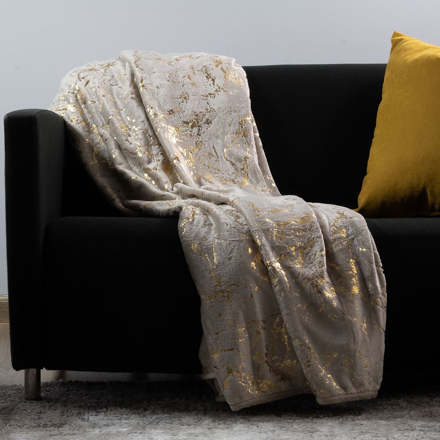 Decorative gold throw blanket placed elegantly on a bed