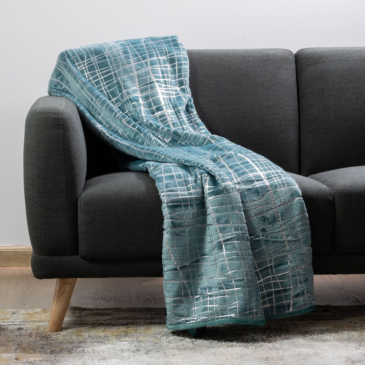 Plush throw blanket neatly folded on a bed in a modern bedroom