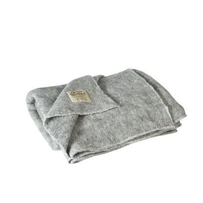 A folded light gray wool blanket with a small beige brand label, shown on a plain white background.