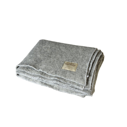 A folded gray wool blanket with a small beige label, shown on a plain white background.