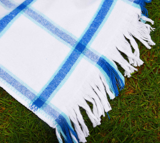 Plaid blanket with blue and white colors on grass