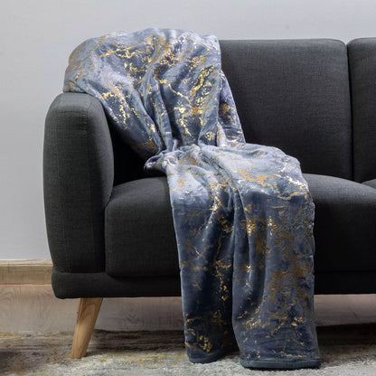 Gray sofa with a decorative blue and gold patterned throw blanket draped over it.