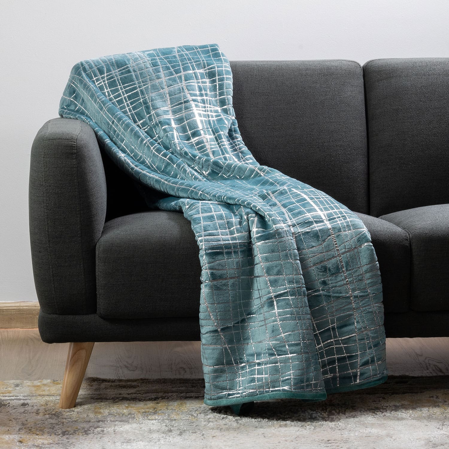 Plush throw blanket neatly folded on a bed in a modern bedroom